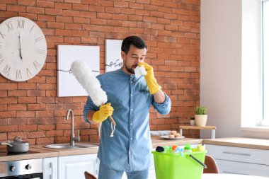 Alerjik adam dairesini temizliyor.