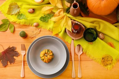 Yemek odasında balkabakları ve sonbahar yaprakları olan güzel bir masa.