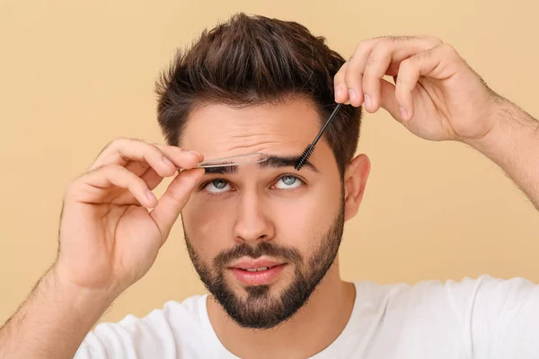 Young Man Correcting Eyebrow Shape Color Background — Stock Photo, Image