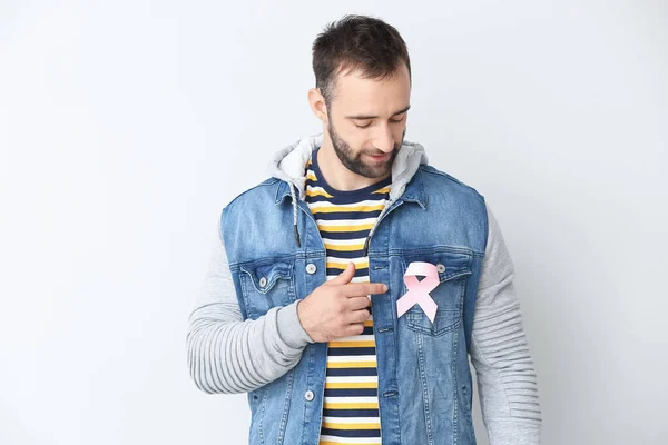 薄い背景にピンクのリボンを持つ若い男 乳がんの認知概念 — ストック写真