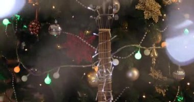 Gitar, güzel Noel ağacının yanında parıldayan bir çelenkle