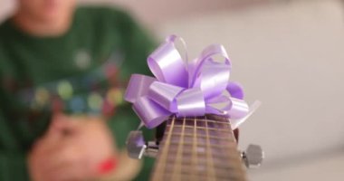 Gitarı evde Noel hediyesi olarak alan genç adam.