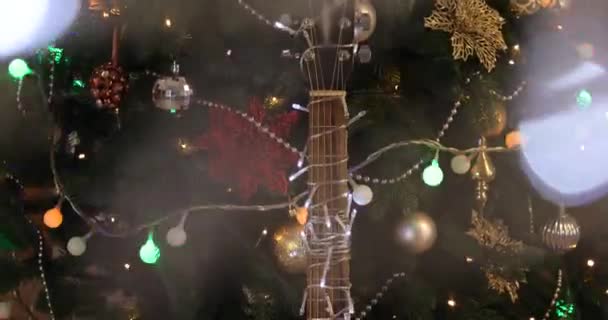Gitarre Mit Leuchtendem Kranz Der Nähe Des Schönen Weihnachtsbaums — Stockvideo