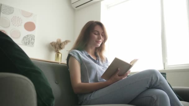 Όμορφη Νεαρή Γυναίκα Διαβάζει Βιβλίο Στο Σπίτι — Αρχείο Βίντεο