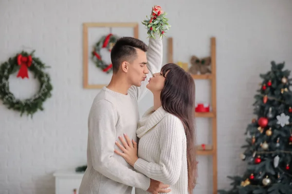 Young Couple Kissing Mistletoe Branch Home Christmas Eve — Stock Photo, Image