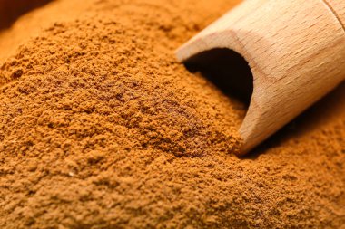 Kepçe ve tarçın tozu, yakın plan.