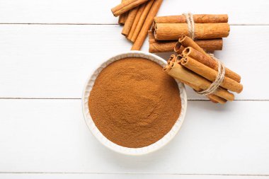 Tarçın tozu ve sopalarla dolu bir kase.