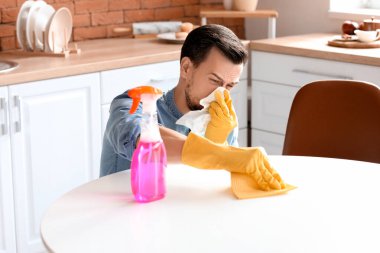 Alerjik adam dairesini temizliyor.