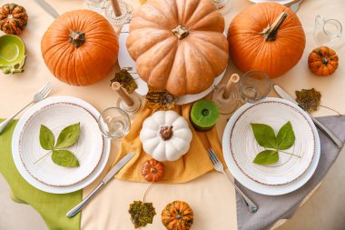 Yemek odasında balkabakları ve sonbahar yaprakları olan güzel bir masa.