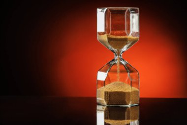 Koyu renk arka planda kum saati. Zaman yönetimi kavramı