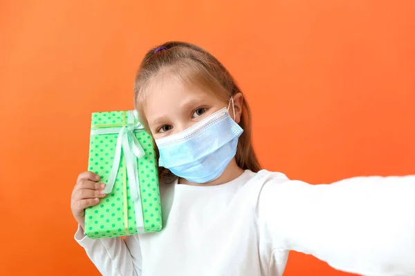 Симпатична Маленька Дівчинка Медичній Масці Подарунком Бере Селфі Кольоровому Фоні — стокове фото