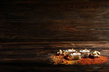 Ahşap arka planda Divaly kutlamaları için baharatlı ve fındıklı mumlar yakmak