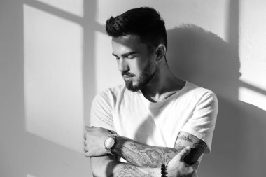 Aydınlık arkaplanda siyah beyaz bir genç adam portresi