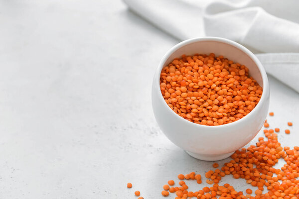 Чаша с сырой чечевицей на светлом столе