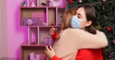 Tıp maskeli kadınlar yeni yılda evde birbirlerini selamlıyorlar. Coronavirüs salgını kavramı