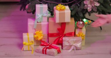 Kadınlar evdeki Noel ağacının altından hediye alıyorlar.