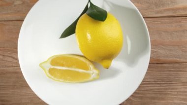 Ahşap arka planda taze limonlu dönen tabak, üst görünüm
