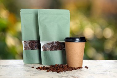 Dışarıdaki masada kahve poşeti ve fincan var.