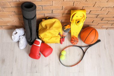 Tuğla duvarın yanında spor aletleri var.