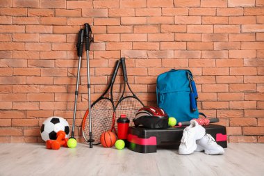 Tuğla duvarın yanında spor aletleri var.