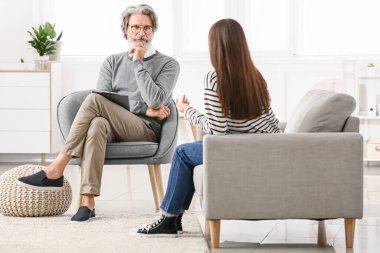 Ofiste genç bir kızla çalışan erkek psikolog.