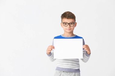 Arka planda boş kâğıt kağıtları olan küçük bir çocuk.