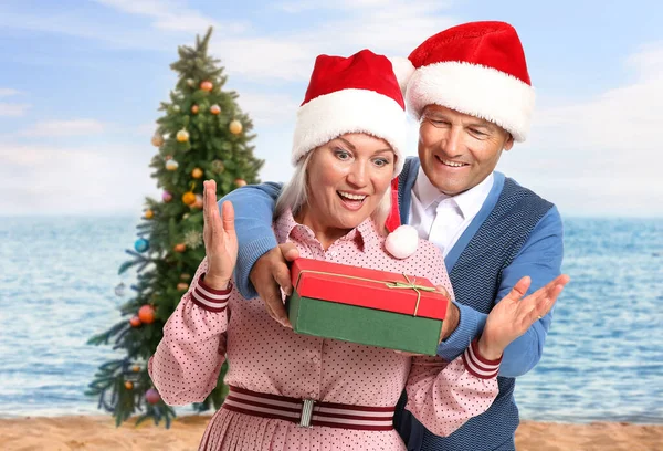 成熟した夫与え彼の妻クリスマスプレゼントでリゾート — ストック写真