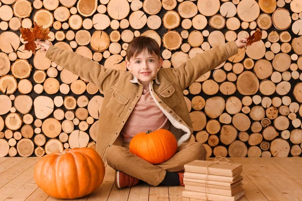 Lindo Niño Con Libros Calabazas Sentado Cerca Pared Madera — Foto de Stock