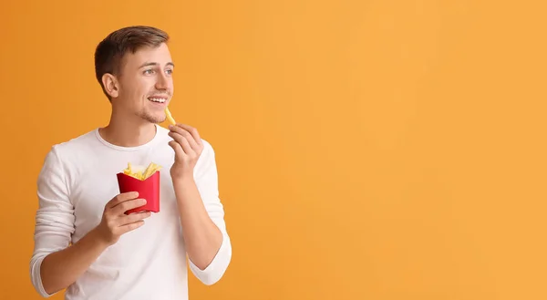 Joven Con Papas Fritas Sobre Fondo Color —  Fotos de Stock