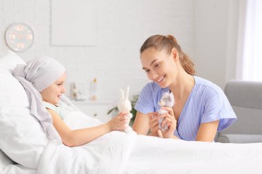 Klinikte kemoterapi gören kızını ziyaret eden bir kadın. Çocukluk kanseri farkındalığı