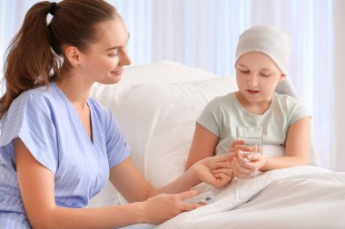 Klinikte kemoterapi gören kızını ziyaret eden bir kadın. Çocukluk kanseri farkındalığı
