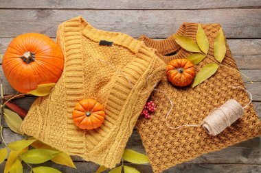 Ahşap arka planda şık giysiler ve ipliklerle sonbahar kompozisyonu