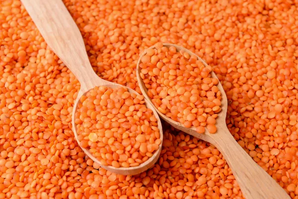 Wooden spoons on red lentils