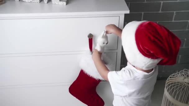 Piccolo Bambino Che Mette Regalo Nel Calzino Natale Appeso Comò — Video Stock