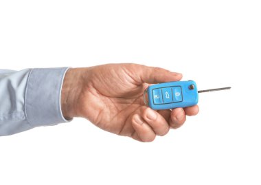 Beyaz arka planda araba anahtarı olan bir erkek.