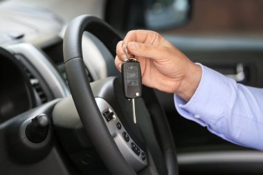 Araba salonunda anahtarı olan adam.