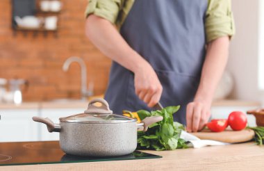 Adam mutfakta yemek pişiriyor.