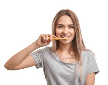 Beyaz arka planda diş fırçası olan genç bir kadın.