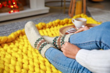 Güzel, genç bir kadın, sıcak çoraplarını giyiyor.