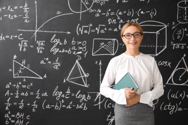 Sınıfta tahtanın yanında olgun matematik öğretmeni.