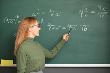 Sınıfta tahtanın yanında olgun matematik öğretmeni.