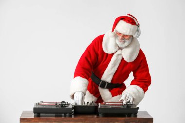 Havalı Noel Baba DJ gri arka planda müzik çalıyor