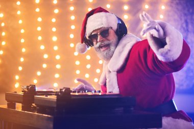 Havalı Noel Baba DJ kulüpte müzik çalıyor.