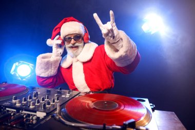 Havalı Noel Baba DJ kulüpte müzik çalıyor.