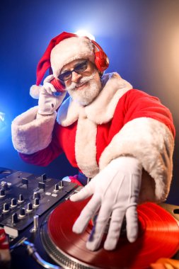 Havalı Noel Baba DJ kulüpte müzik çalıyor.