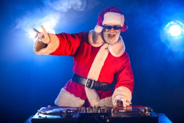 Havalı Noel Baba DJ kulüpte müzik çalıyor.