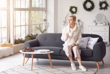 Güzel, genç bir kadın, sıcak bir çay içiyor.