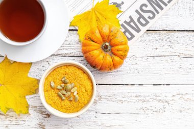 Lezzetli balkabağı pudingi, bir fincan çay ve gazete.