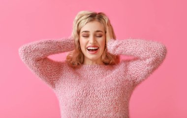 Renkli arka planda kalın giysiler içinde güzel bir kadın.