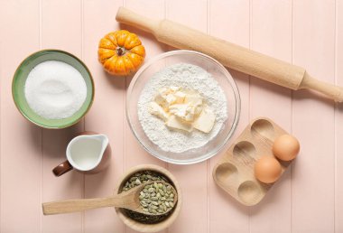 Renkli ahşap zemin üzerinde balkabağı turtası hazırlamak için gerekli malzemeler